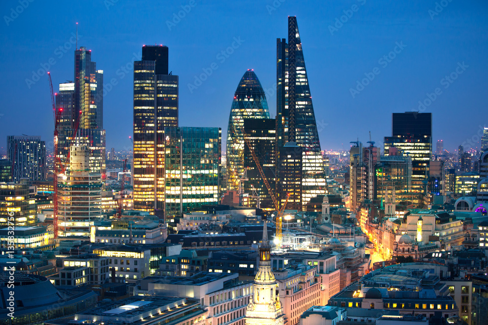 Obraz premium City of London at sunset with lights and reflection. View at the business and banking aria with modern skyscrapers