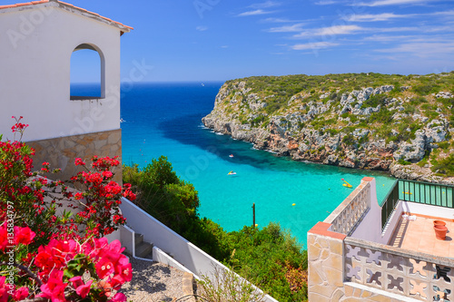 Holiday villa overlooking Cala Porter bay with turquoise sea water, Menorca island, Spain