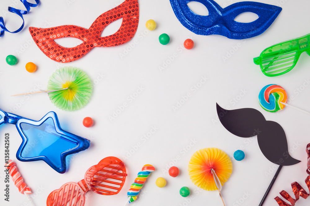 Carnival party concept with costume mask and glasses on white background. Top view from above