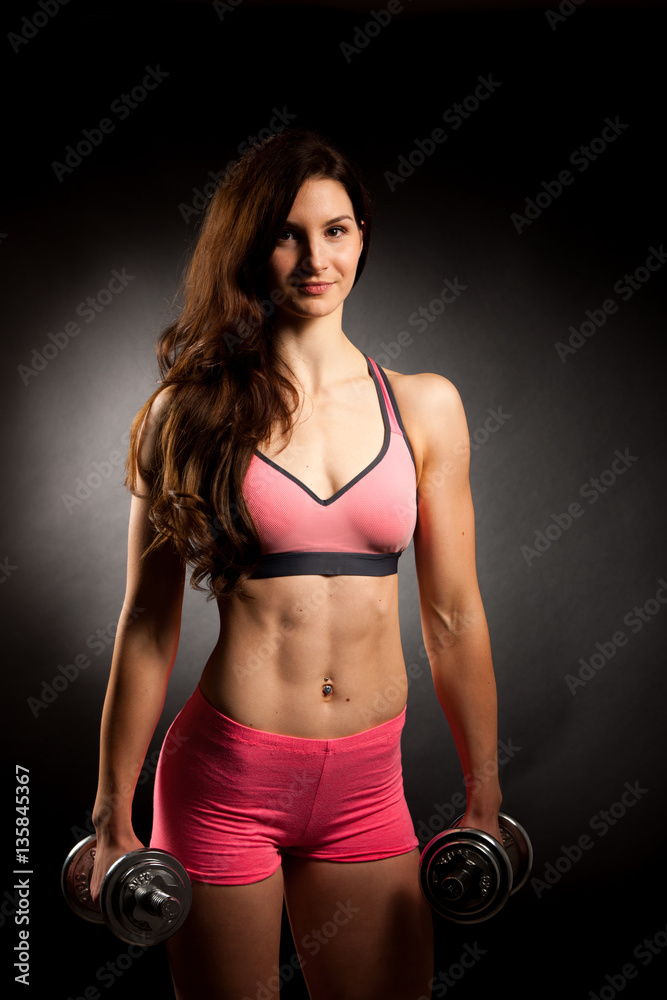 Atractive fit woman works out with dumbbells as a fitness concep Atractive fit woman works out with dumbbells as a fitness concep