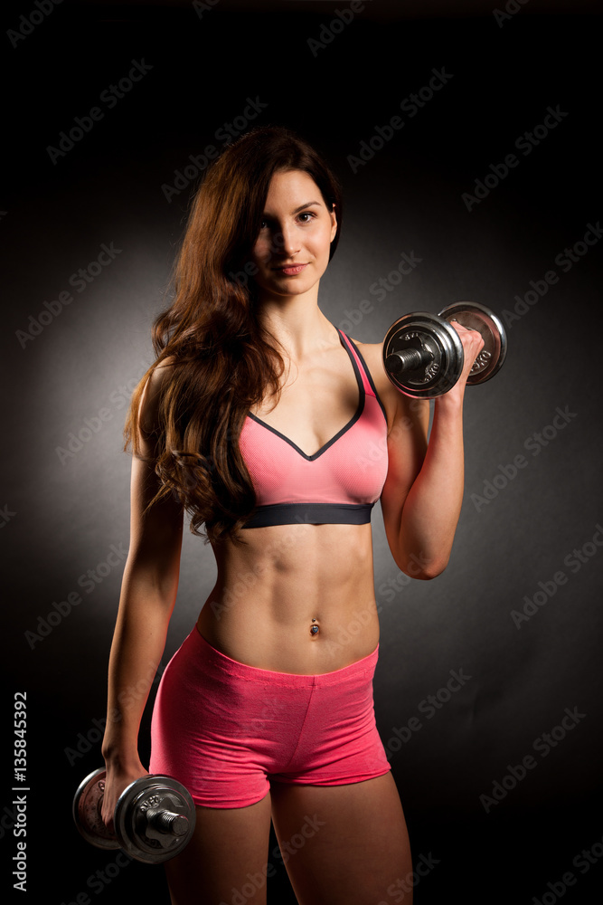 Atractive fit woman works out with dumbbells as a fitness concep Atractive fit woman works out with dumbbells as a fitness concep