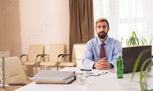Businessman sitting at a desk with laptop in office