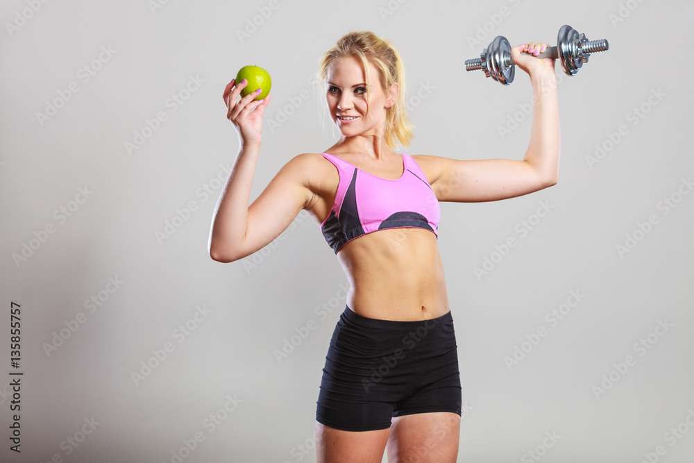 Diet fit body. Girl holds dumbbells and apple fruit Diet fit body. Girl holds dumbbells and apple fruit