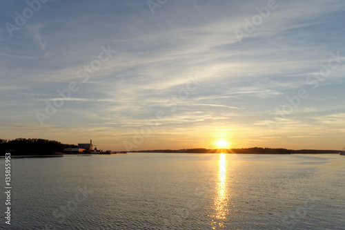 A view of the calm golden sunset on the river with the sun reflected in it  Volga  Russia