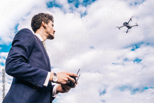 Mann fliegt Drohne/Drohnenpilot im Anzug