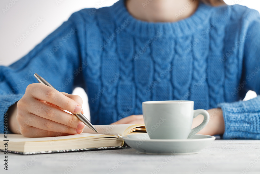 Woman write in notebook and drink coffee Woman write in notebook and drink coffee