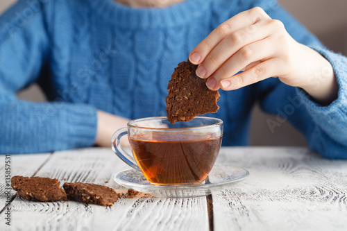 Fotografia girl dunk biscuits in tea