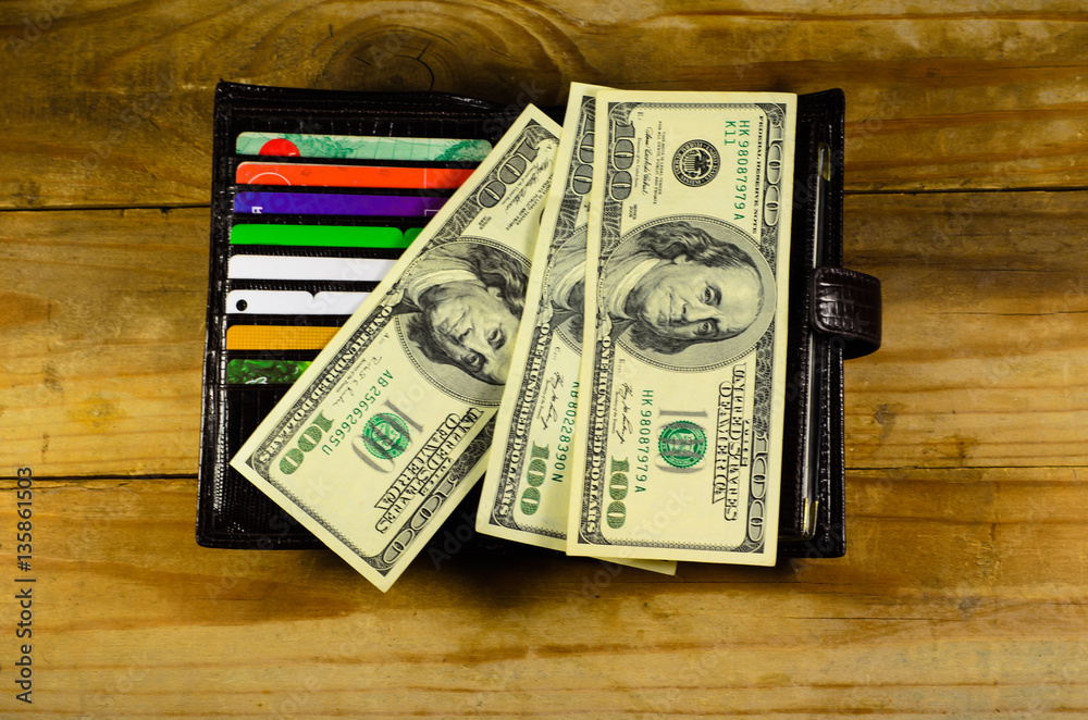 Open wallet with money and credit cards on wooden table Open wallet with money and credit cards on wooden table