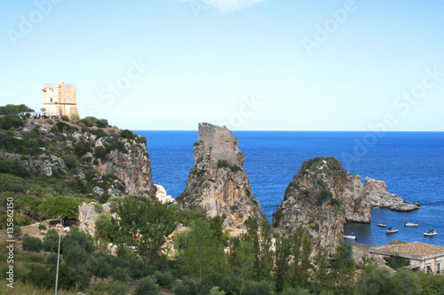 Top view of the rocks, medieval tower and Mediterranean ocean in Scopello Beach, Sicily, Italy