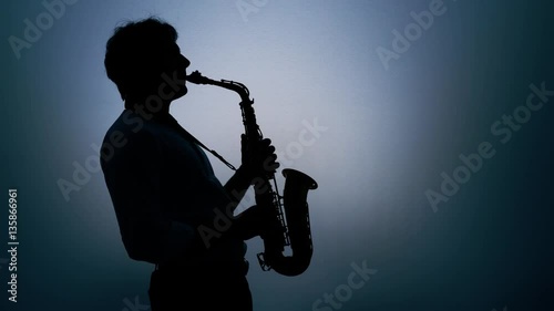 Saxophone player over a gray background. Real time.