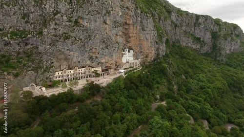Flying to front of monastery of Ostrog in the rock of Ostroska Greda, Montenegro. Aerial view
