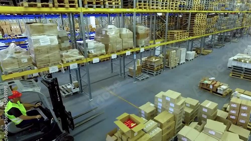 Worker in loader transport rides in warehouse storage HD video. Goods transportation with forklift. Man working on lift truck