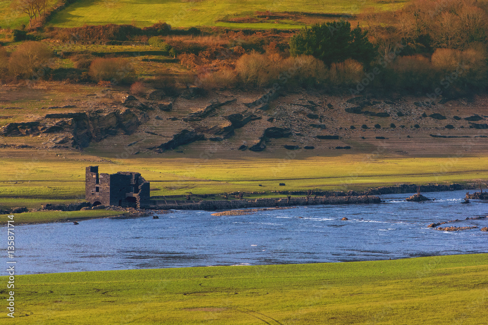 Fototapeta premium Ruins of an old house in San Estevo water reservoir. The house is generally submerged by the waters of Miño river
