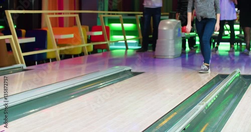 Young woman playing bowling game and throwing ball to lane 4k leisure video. Friends playing, girl happy for win. Lucky shot hit. Hobby and competitions