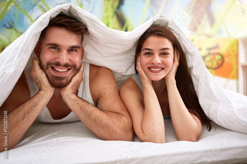 Couple in bed under blanket