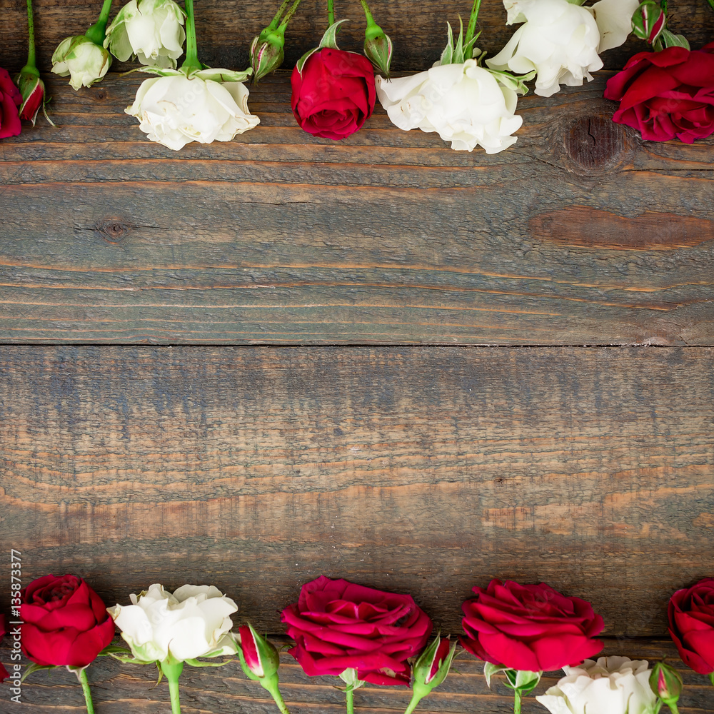Fototapeta premium Floral frame with red and white roses on wood background. Flat lay, top view. Valentine's background