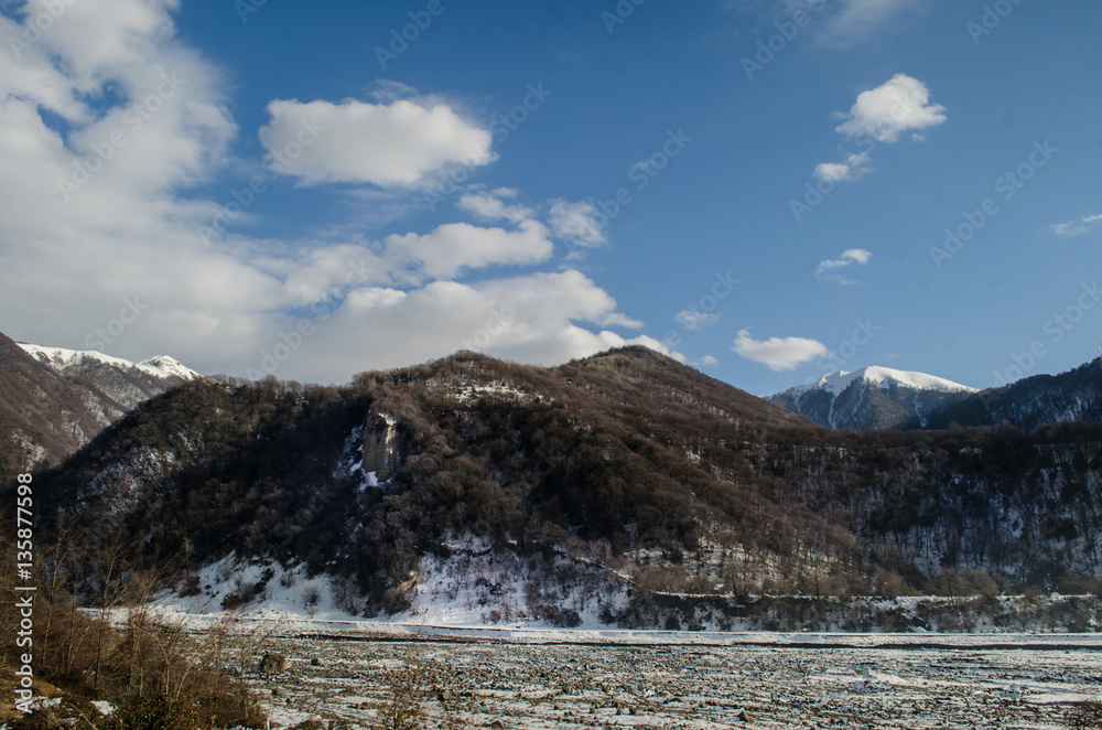 Beautiful Landscape of snowy winter greater Caucasus mountains. Sunny weather, trees clouds fields of Azerbaijan nature