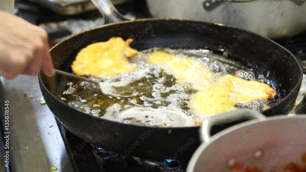 A female cook draining chicken cutlets from the oil, 4K A female cook draining chicken cutlets from the oil, 4K