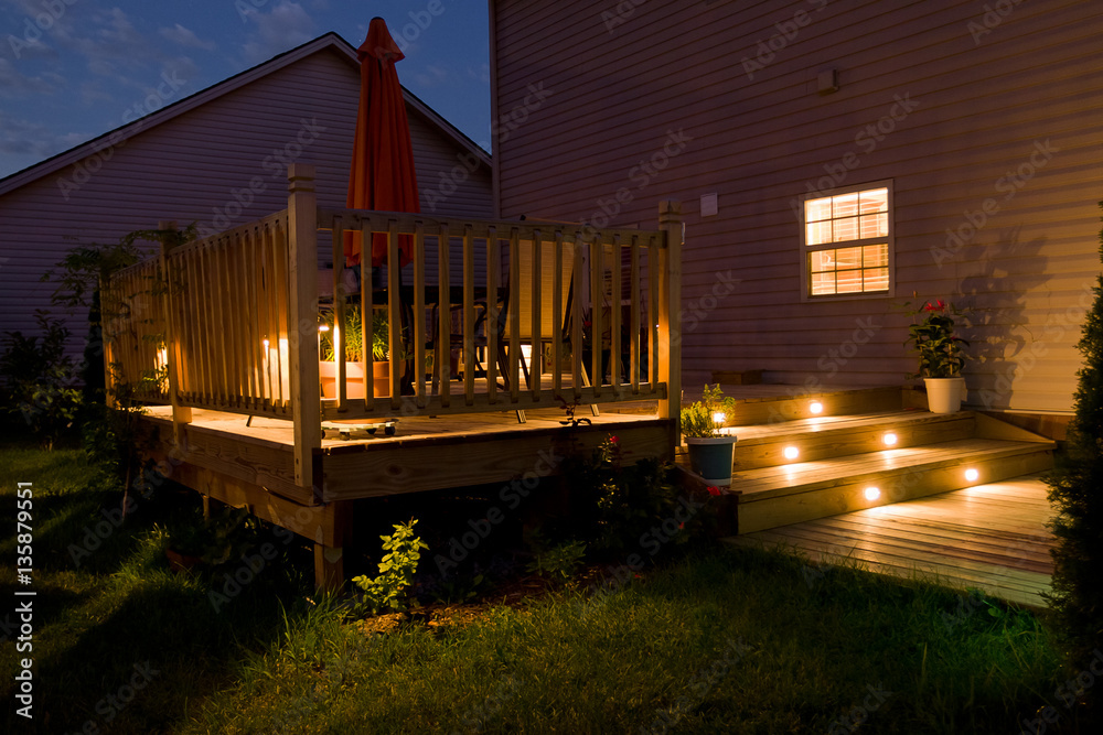 Wooden deck and patio of family home at night. - obrazy, fototapety, plakaty 