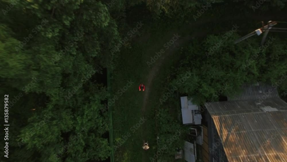 Aerial shot of a child in the countryside catching flying down copter, boy smiling to the camera Aerial shot of a child in the countryside catching flying down copter, boy smiling to the camera