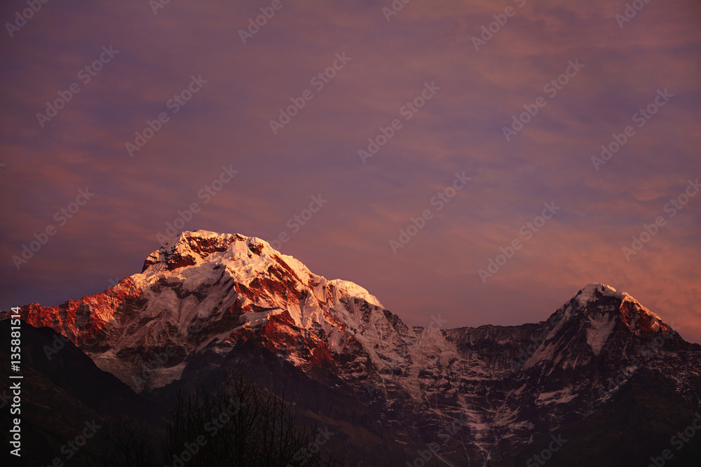 Amazing breathtaking view of sunset over craggy summits of the Himalayan mountain range. Scenery of icy peaks of majestic ancient mountains standing high above valley in the Annapurna Sanctuary