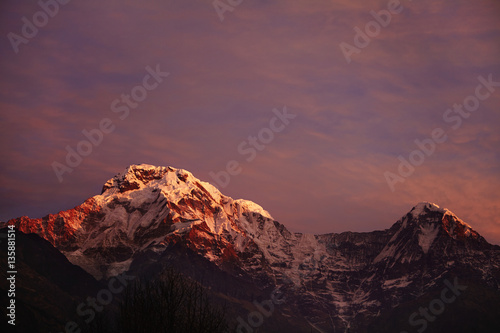 Amazing breathtaking view of sunset over craggy summits of the Himalayan mountain range. Scenery of icy peaks of majestic ancient mountains standing high above valley in the Annapurna Sanctuary