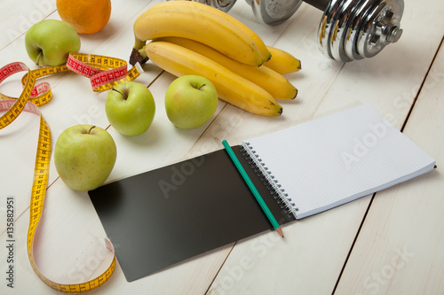 Fruits and diet plan on a white wooden table