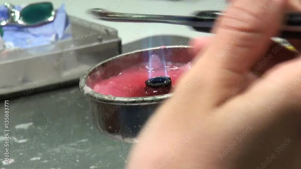 Dentist is applying hot wax into a mold. Dental technologist, the