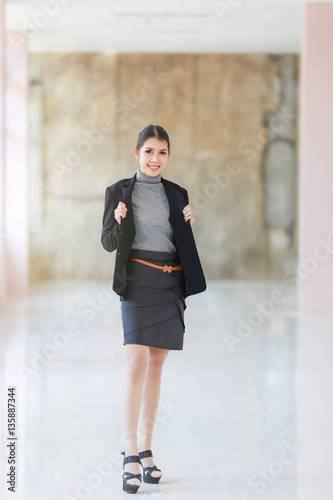Business woman , Asian people young beautiful businesswoman smile and wear shirt black suit, space brown wall background © noombluesman