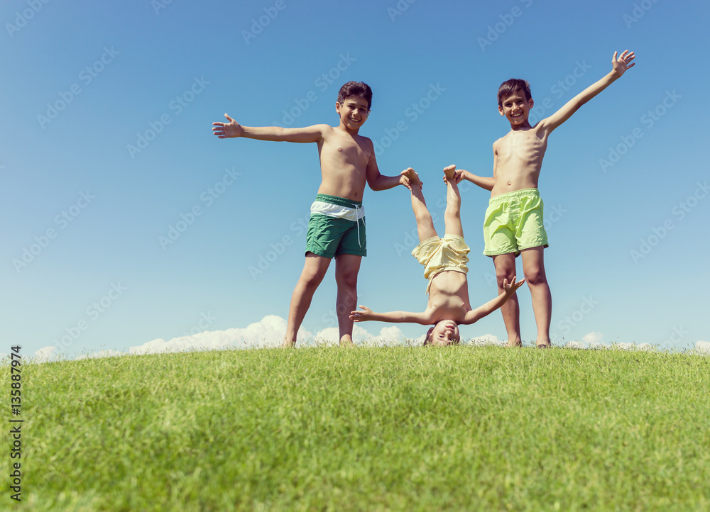 Brothers playing upside down on green meadow Brothers playing upside down on green meadow