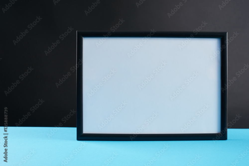 empty modern style frame on blue table against dark background empty modern style frame on blue table against dark background