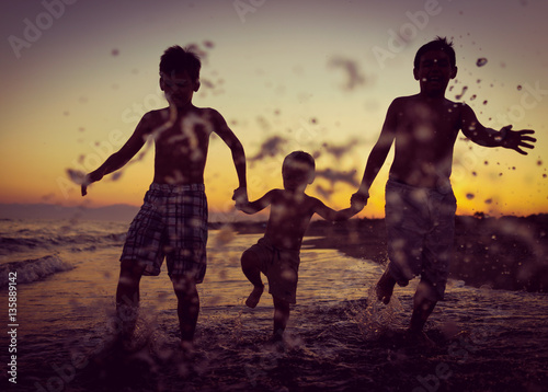 Fun kids playing splash at beach