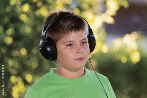 Portrait of boy with headphones outdoors