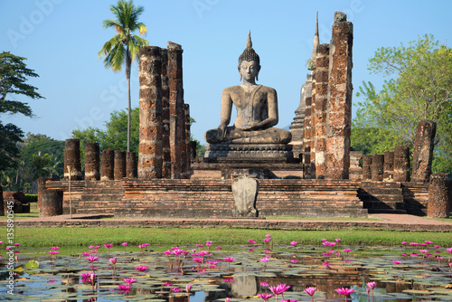 Fototapeta View of a sculpture of the sitting Buddha on ruins of the temple Wat Chana Songkram