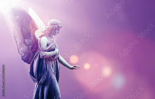 Angel in heaven over purple sky background photo