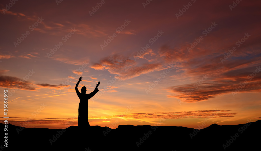 Statue of Jesus over beautiful sunset