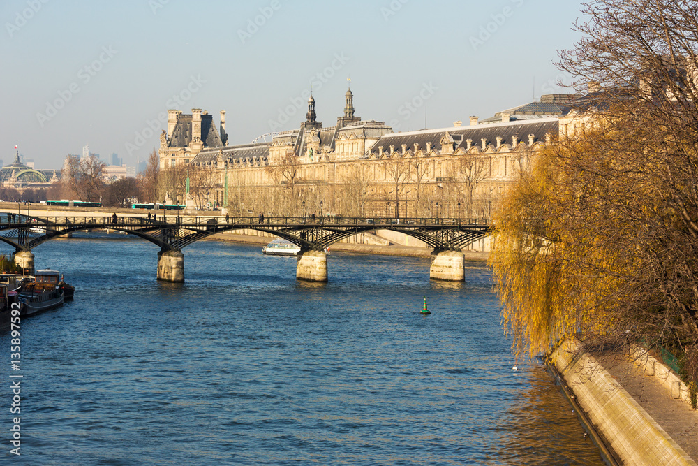 Fototapeta premium Bridges on the Seine river and passenger ships as a public transport vehicle in Paris.