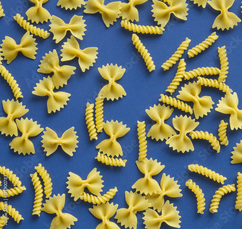 Pasta bow and spiral shape on blue background
