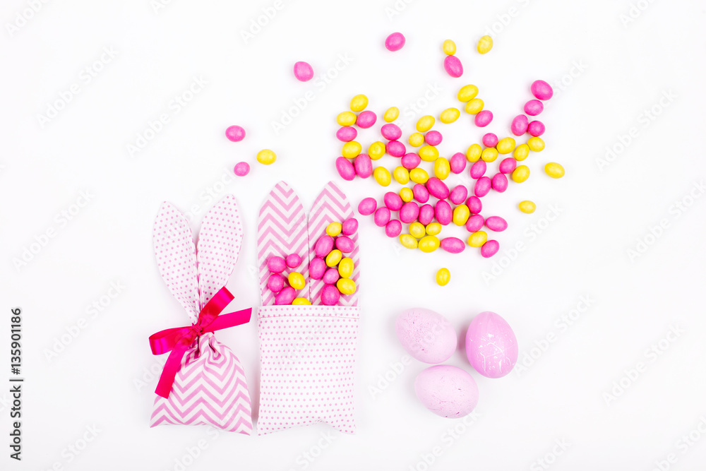 Bunny treat bag with pink candy and eggs on white background; Easter concept.