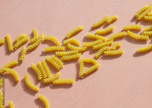 Pasta spiral shape on pink background
