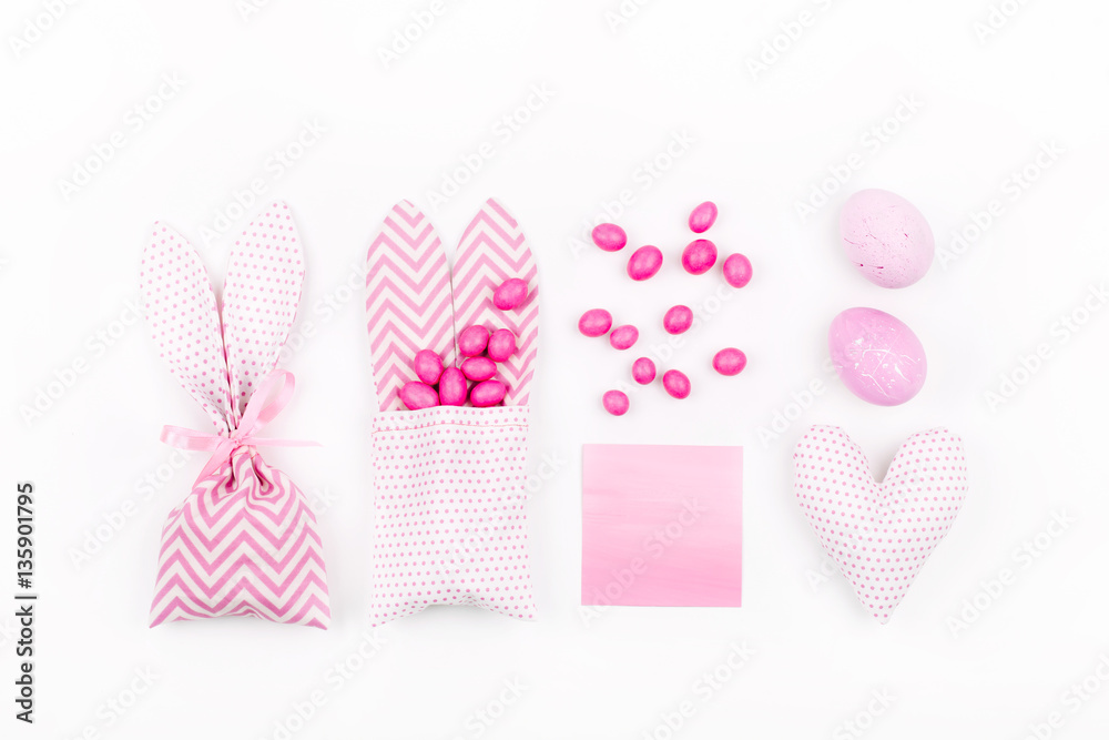 Bunny treat bag with pink candy, empty card, eggs and heart. Easter concept on white background Bunny treat bag with pink candy, empty card, eggs and heart. Easter concept on white background