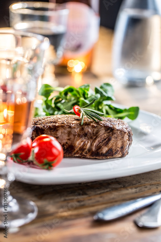 Beef Steak. Juicy beef steak. Gourmet steak with vegetables and glass of rose wine on wooden table.