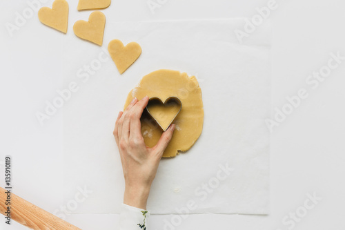 Female Cutting out Heart Shaped Biscuit on White Table