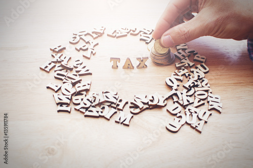 Tax Concept with wooden block and coins.