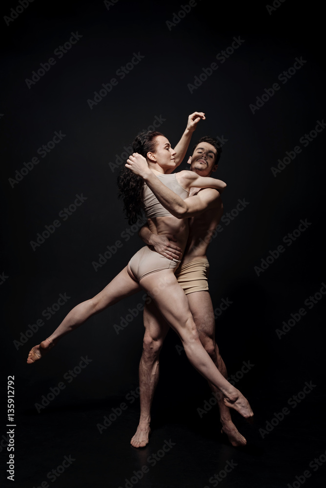 Talented performers dancing isolated in black background