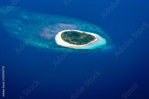 An island in an atoll chain seen from the air in the Maldives