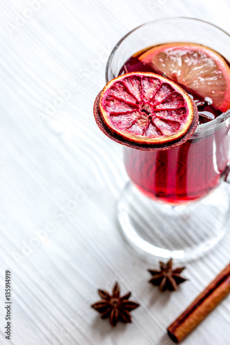 mulled wine with spices in cup on wooden background