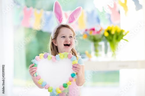 Little girl in bunny ears on Easter egg hunt