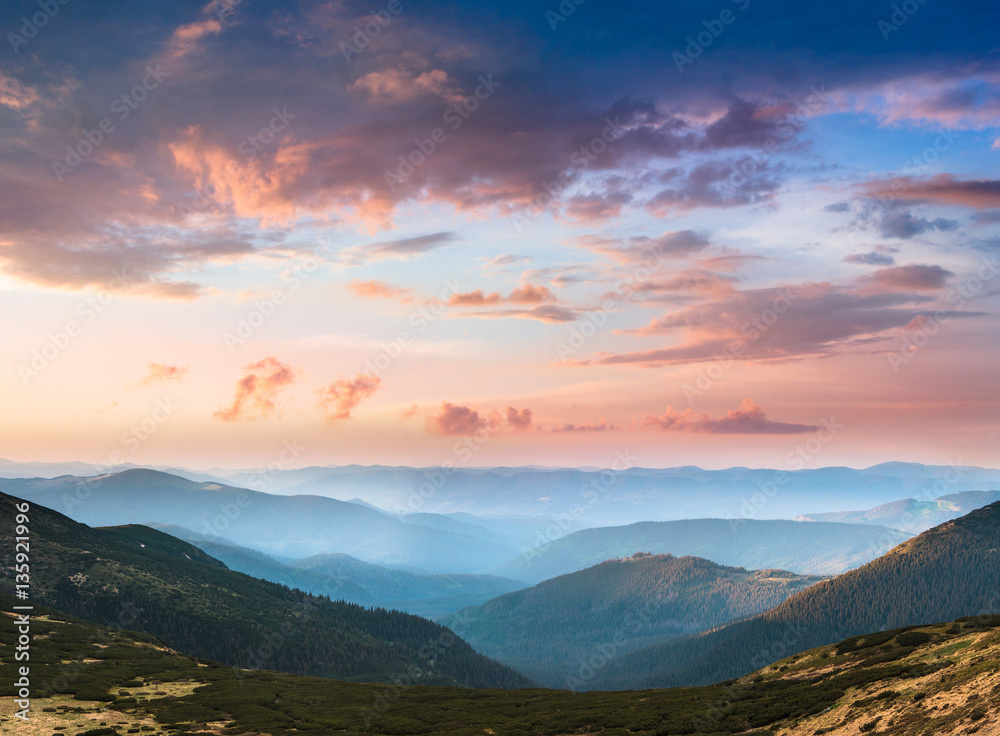 Beautiful landscape in the mountains at sunset. View of colorful sky with clouds.