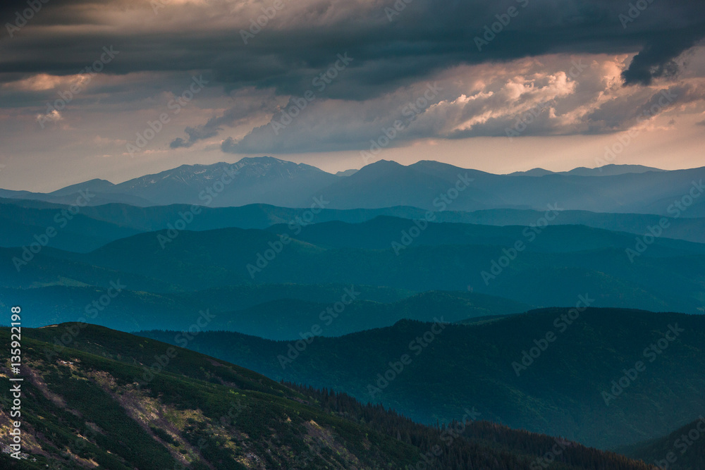 Sunset over layers of mountains.